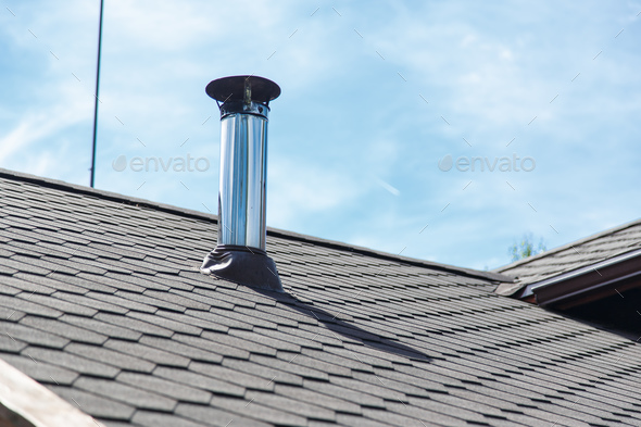 Chimney pipe from stainless steel on the roof of the house Stock Photo by  Vladdeep