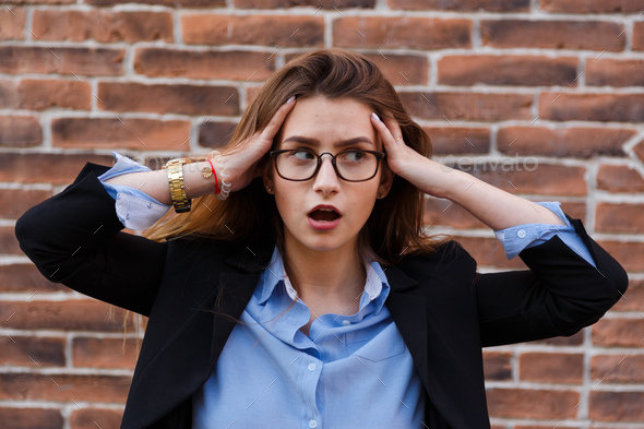 Frustrated business woman holding his hands to her head in frustration. - Stock Photo - Images