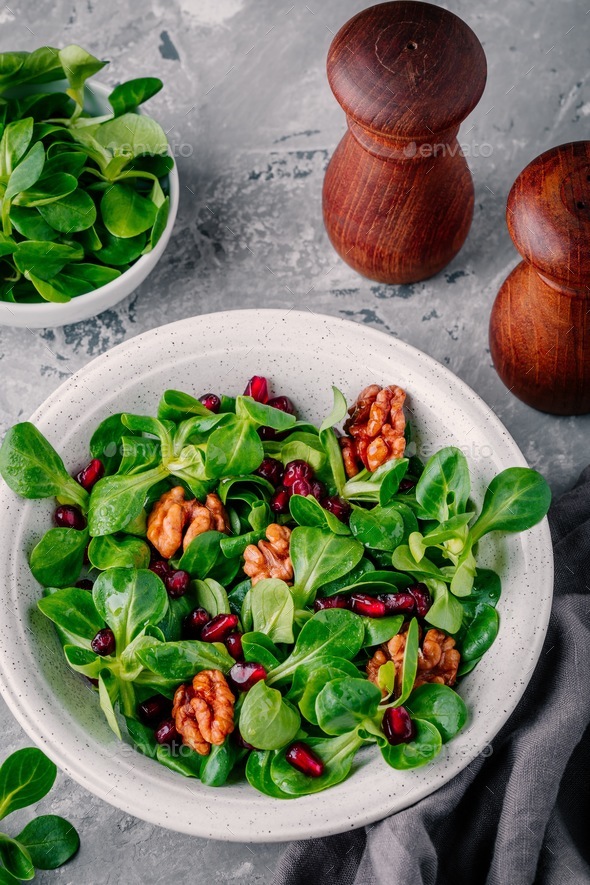 Healthy green Lamb’s lettuce salad with walnuts and pomegranate seeds ...