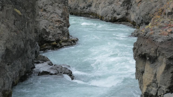 Water Stream of Mountain River in Iceland Running between Black Basalt Rocks