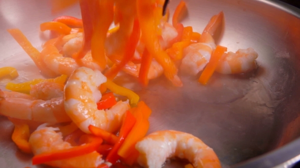 Shrimps and Paprika Are Falling Into a Skillet with Oil alt