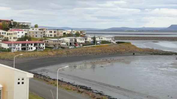 Outskirts of Small Icelandic Town with Living Houses, River and Mountains Are in Background