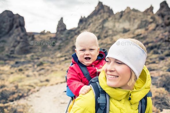 Young mother with little boy travelling in backpack - Stock Photo - Images