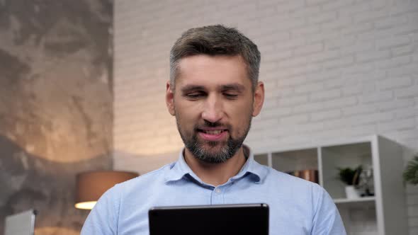 Close Up Smiling Businessman Uses Tablet at Home Office alt
