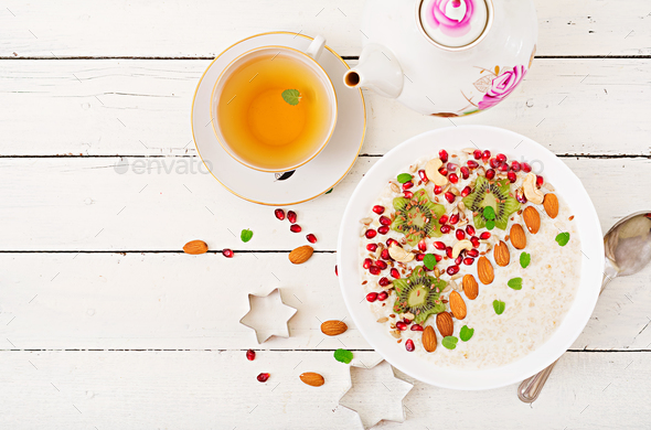 Tasty and healthy oatmeal porridge with kiwi, pomegranate and seeds. - Stock Photo - Images