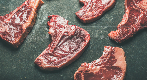Raw beef meat steak cuts over black background - Stock Photo - Images