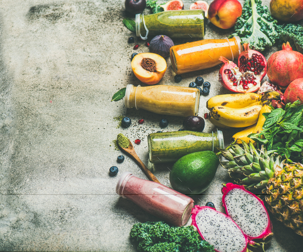 Colorful smoothies in bottles with fresh fruit on concrete background - Stock Photo - Images