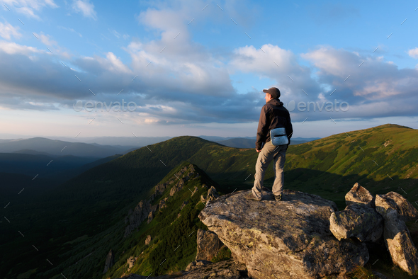 Alone tourist sitting on the edge of the cliff - Stock Photo - Images