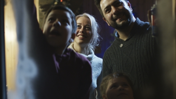 Happy Family Spraying Window with Artificial Snow alt