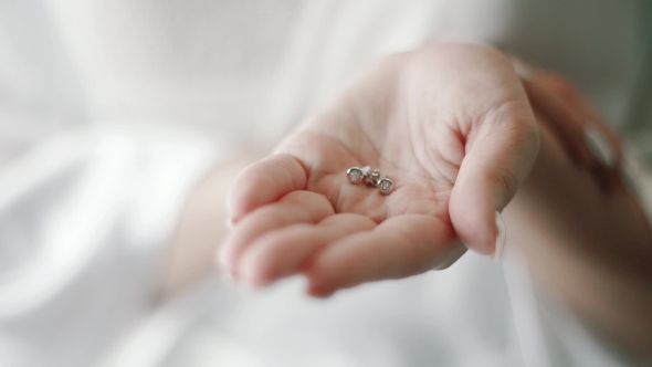 Bride Holding Earrings in Hands alt