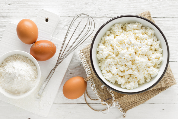 Culinary background with ingredients for cooking, cottage cheese, baking flour, sugar and eggs - Stock Photo - Images