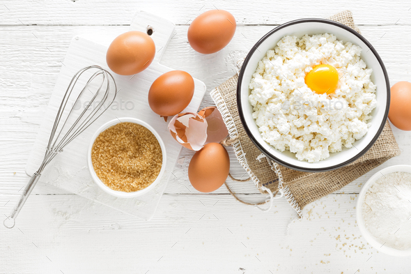 Culinary background with ingredients for cooking, cottage cheese, baking flour, sugar and eggs - Stock Photo - Images