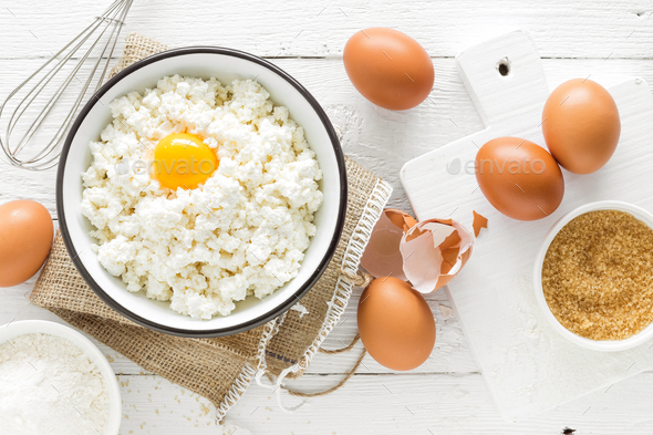 Culinary background with ingredients for cooking, cottage cheese, baking flour, sugar and eggs - Stock Photo - Images