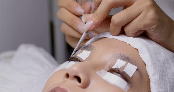 Female woman having eye lash extension in beauty salon alt