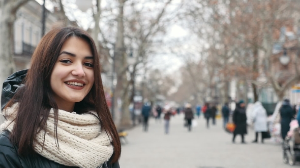 A Happy Girl Stands in a Park Alley and Smiles Sincerely in Winter in Slo-mo