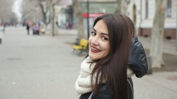A Charming Girl Goes and Turns Gracefully in a City Street in Winter in Slo-mo