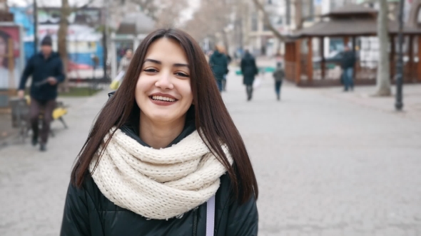 A Laughing Girl Strolls in a City Street and Looks Sweet in Winter in Slo-mo