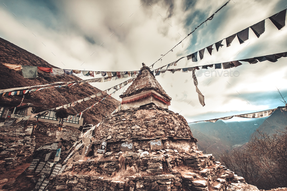 Prayer flags and buddhist stupa on trekking route - Stock Photo - Images