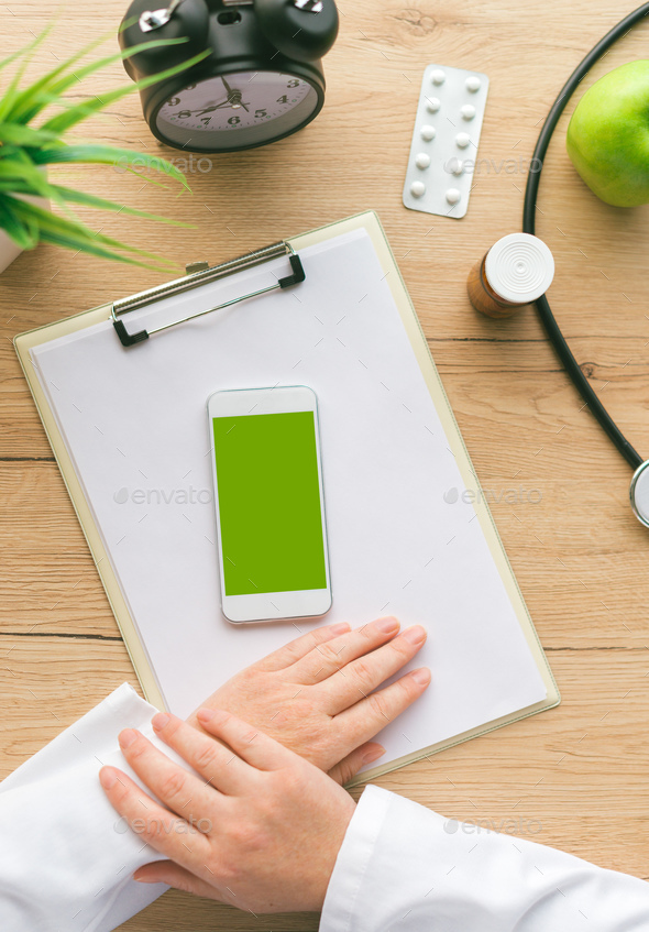 Doctor using smartphone app in hospital office - Stock Photo - Images