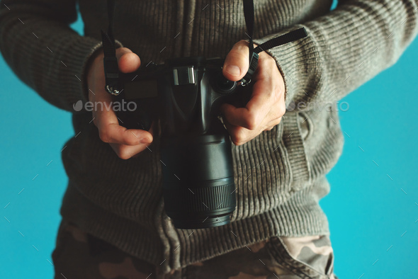Photographer holding full frame sensor DSLR camera Stock Photo by stevanovicigor