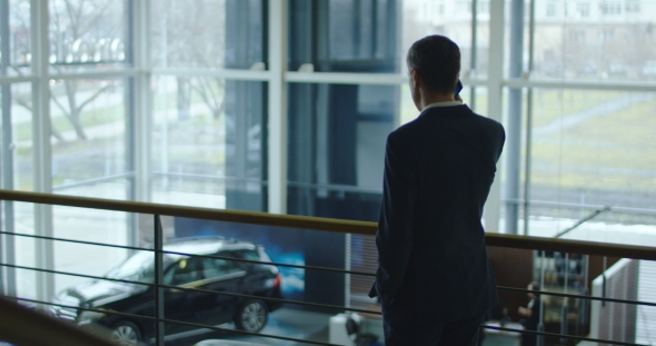 Businessman Talking on Phone in Showroom alt