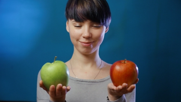 A Girl Chooses Between a Red and Green Apple
