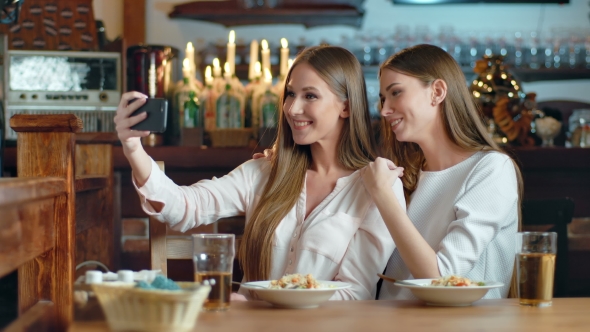 Two Beautiful Women Taking Selfie in Cafe alt