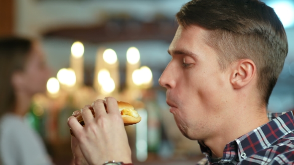 Man in a Restaurant Eating a Hamburger alt