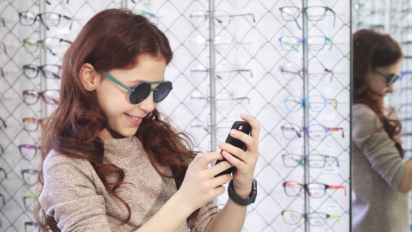 Cute Little Happy Girl Taking Selfies at the Eyewear Store alt