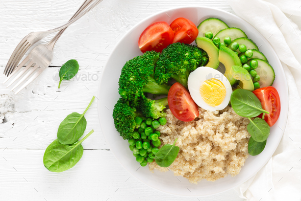 Healthy detox dish with egg, avocado, quinoa, spinach, fresh tomato, green peas and broccoli - Stock Photo - Images