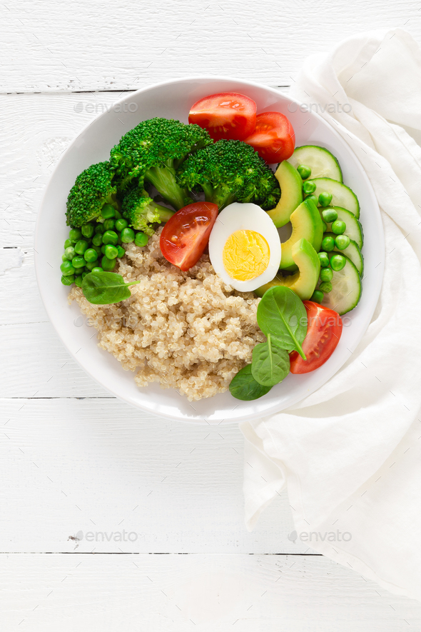Healthy detox dish with egg, avocado, quinoa, spinach, fresh tomato, green peas and broccoli - Stock Photo - Images