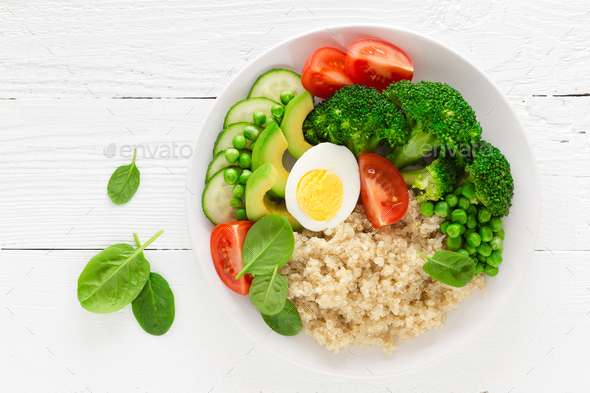 Healthy detox dish with egg, avocado, quinoa, spinach, fresh tomato, green peas and broccoli - Stock Photo - Images