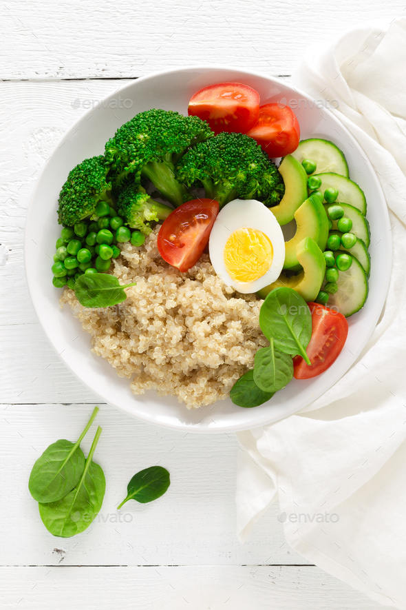 Healthy detox dish with egg, avocado, quinoa, spinach, fresh tomato, green peas and broccoli - Stock Photo - Images