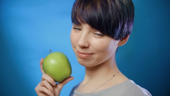 Attractive Brunette Girl Holding a Green Apple
