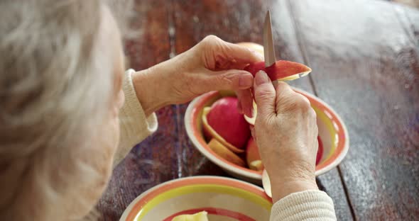 Closeup Grandmother's Old Women's Hands Peel a Ripe Red Apple alt