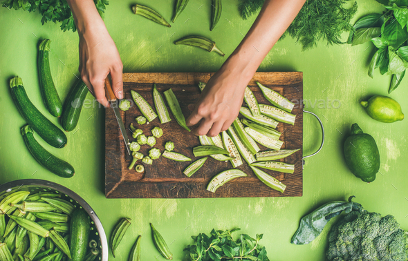 Flat-lay of healthy green vegan cooking ingredients on board Stock Photo by sonyakamoz