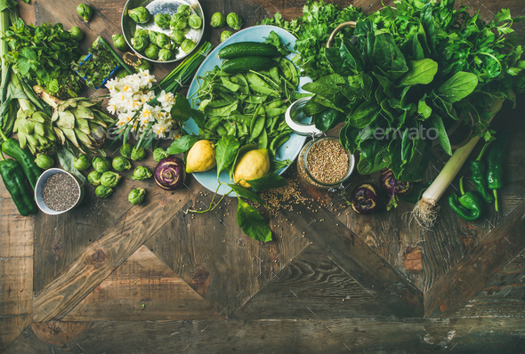 Spring healthy vegan food cooking ingredients over wooden background - Stock Photo - Images