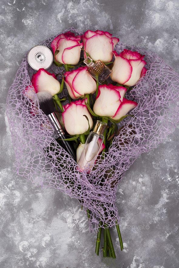 Bouquet of beautiful roses with cosmetics on gray concrete - Stock Photo - Images