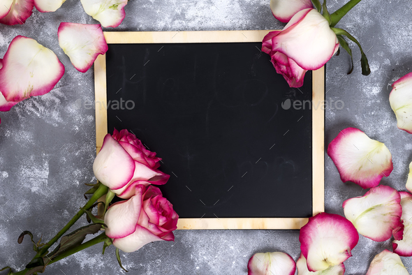 Beautiful rose flowers on gray stone table. Floral border. - Stock Photo - Images