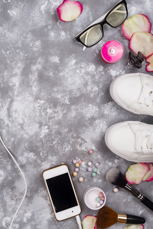 cosmetics with perfume, phone and sneakers on a gray background with copy space - Stock Photo - Images