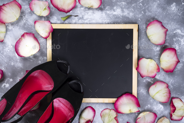 Beautiful rose flowers and woman shoes on gray stone table. Floral border. - Stock Photo - Images