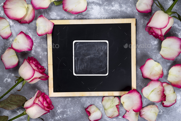 Beautiful rose flowers on gray stone table. Floral border. - Stock Photo - Images