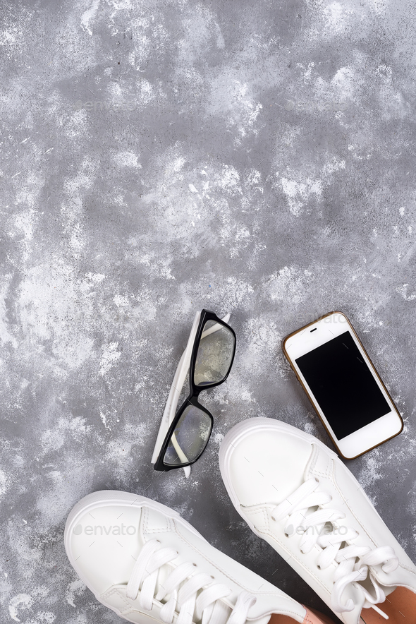 Flat lay Of White Sneakers On stone Background with phone and headphones. - Stock Photo - Images