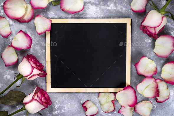 Beautiful rose flowers on gray stone table. Floral border. - Stock Photo - Images