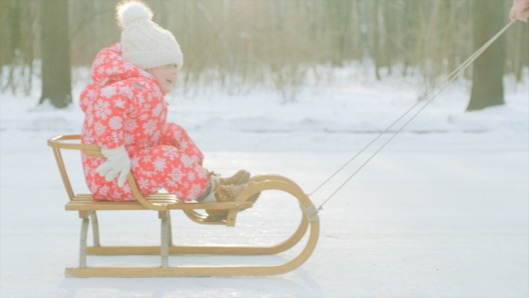 Happy Little Boy on the Sledge in the Winter Park
