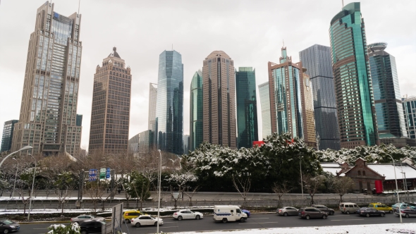 Park with Trees and Road Covered with Snow Surrounded By Skyscrapers in the Pudong Area. Shanghai