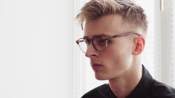 Handsome Young Man in Glasses Looking Away and Turns Head