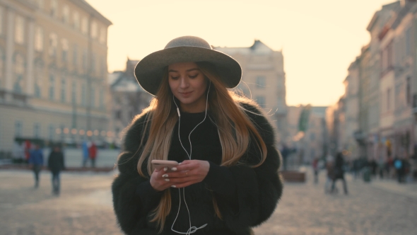 Young Girl Going the City and Listening To Music on the Phone alt