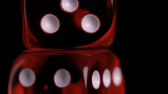 Rotating Red Dice Around Its Axis, on a Black Background alt
