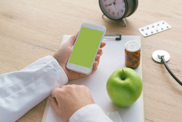 Doctor advising apple instead of pills and antibiotics - Stock Photo - Images